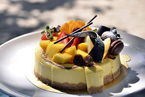 a cheesecake with fresh fruits and macarons