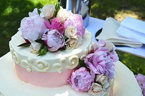 cream cake decorated yellow roses and pink peonies